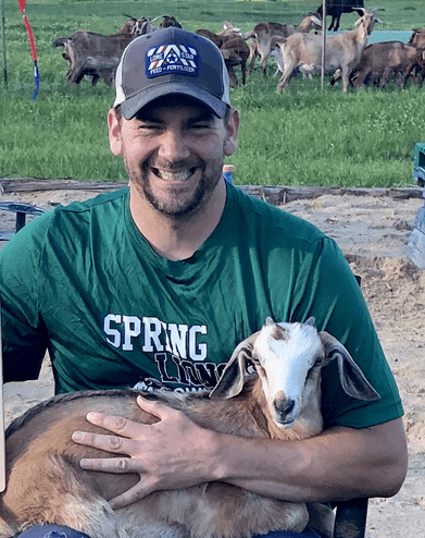 Justin holding goat About Us